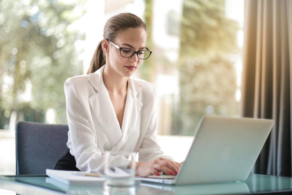 Confident businesswoman using a laptop at her desk, focused on her work.